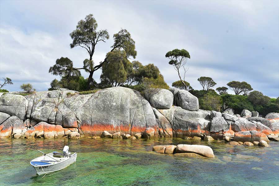 Littoral de la côte est de Tasmanie avec rochers orangés et plage de sable blanc Littoral de la côte est de Tasmanie avec rochers orangés et plage de sable blanc